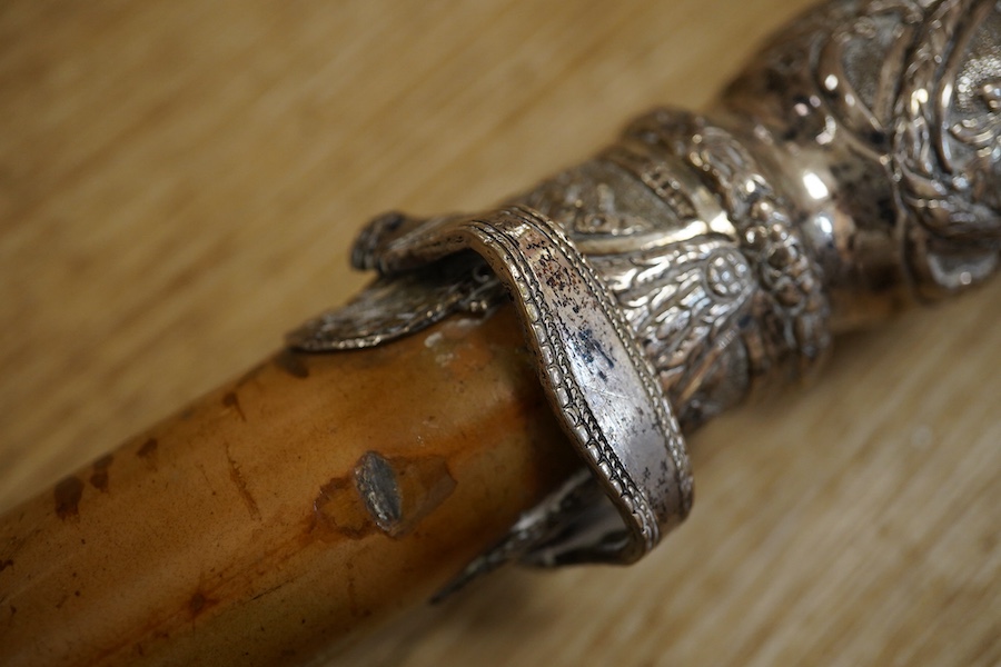Three 19th century walking sticks, two with silver tops to include a dogs head example, one with unmarked embossed white metal top, largest 97cm in length